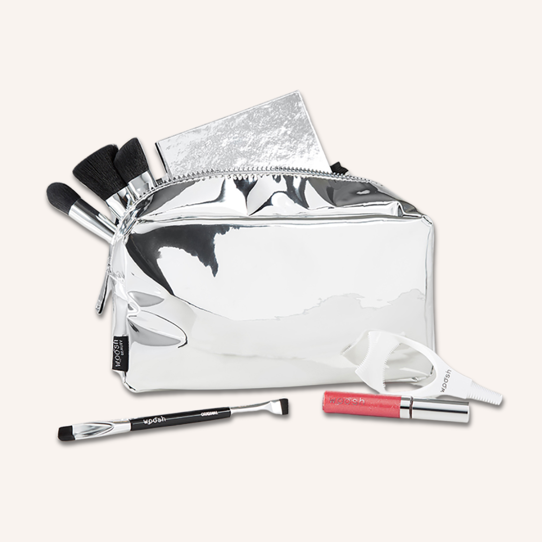 Demonstration of what you can fit in the Woosh Beauty silver essential makeup bag shown with Woosh Beauty essential products