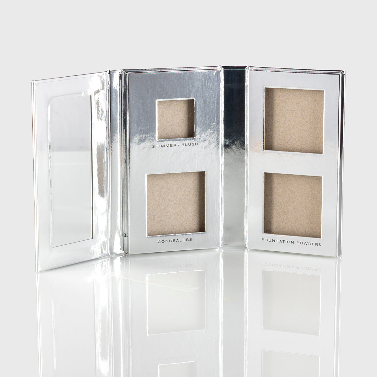 a photo of an empty silver makeup palette with mirrored flap and slots for 1 blush or shimmer, 2 concealers and 2 foundation powders