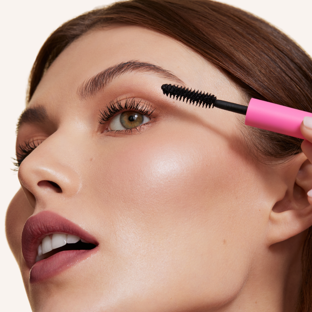 Close up image of model applying mascara
