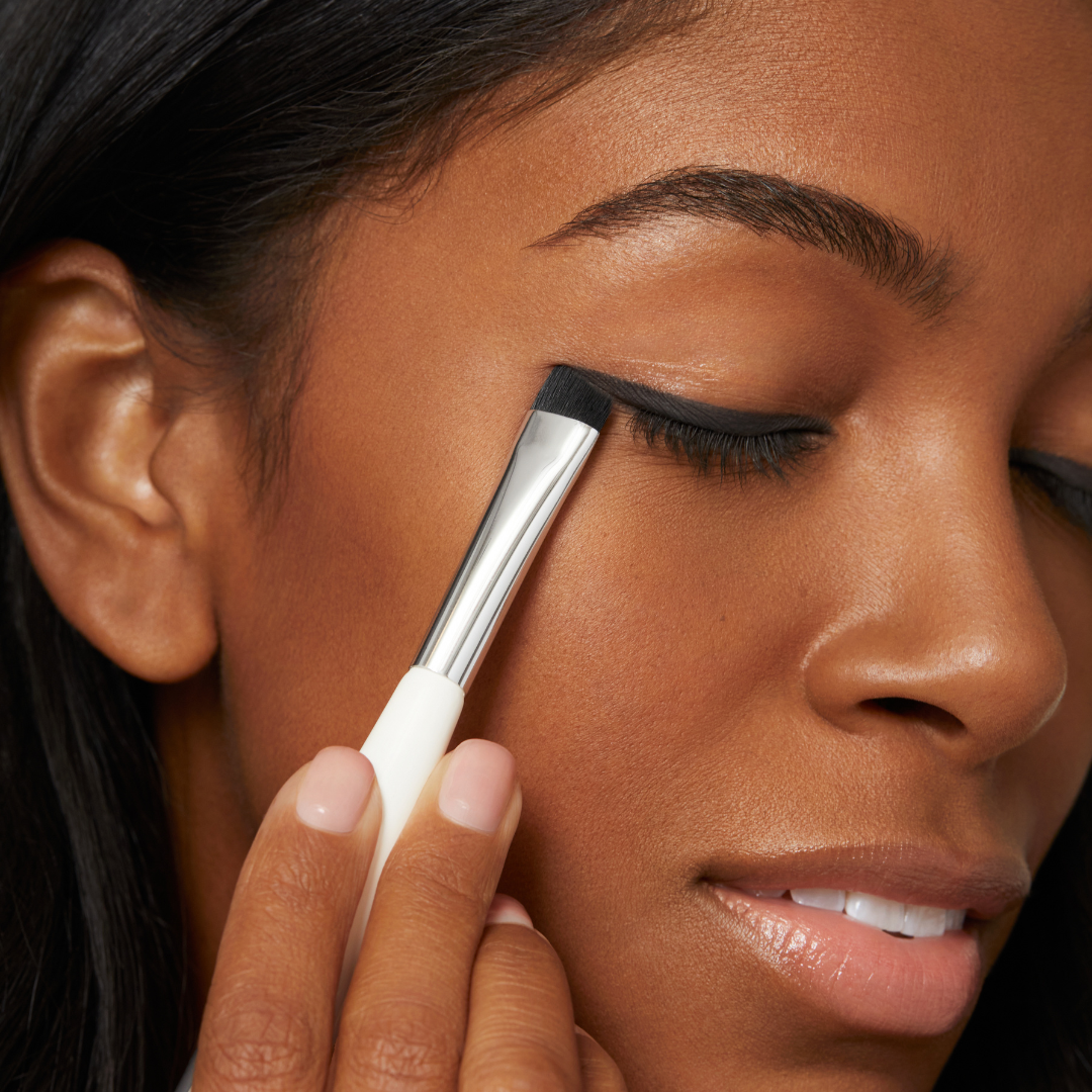 angled brush end applying matte black eye shadow eyeliner