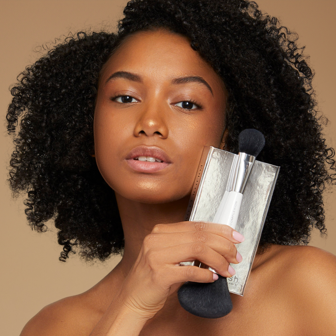 model holding our complexion brush