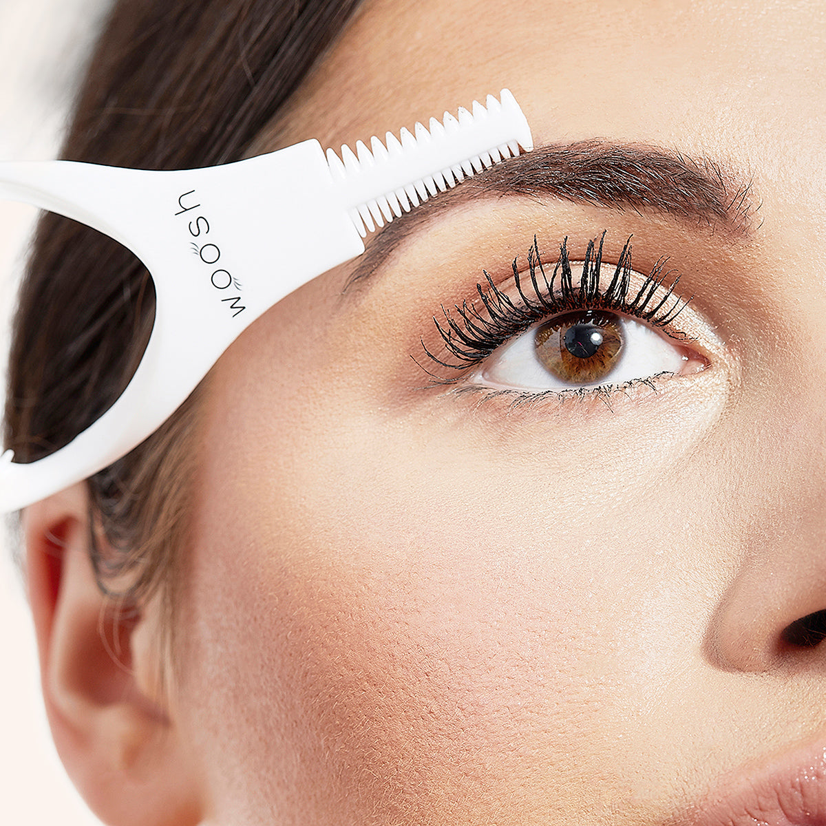 mascara shield being used to brush out eyebrow hairs
