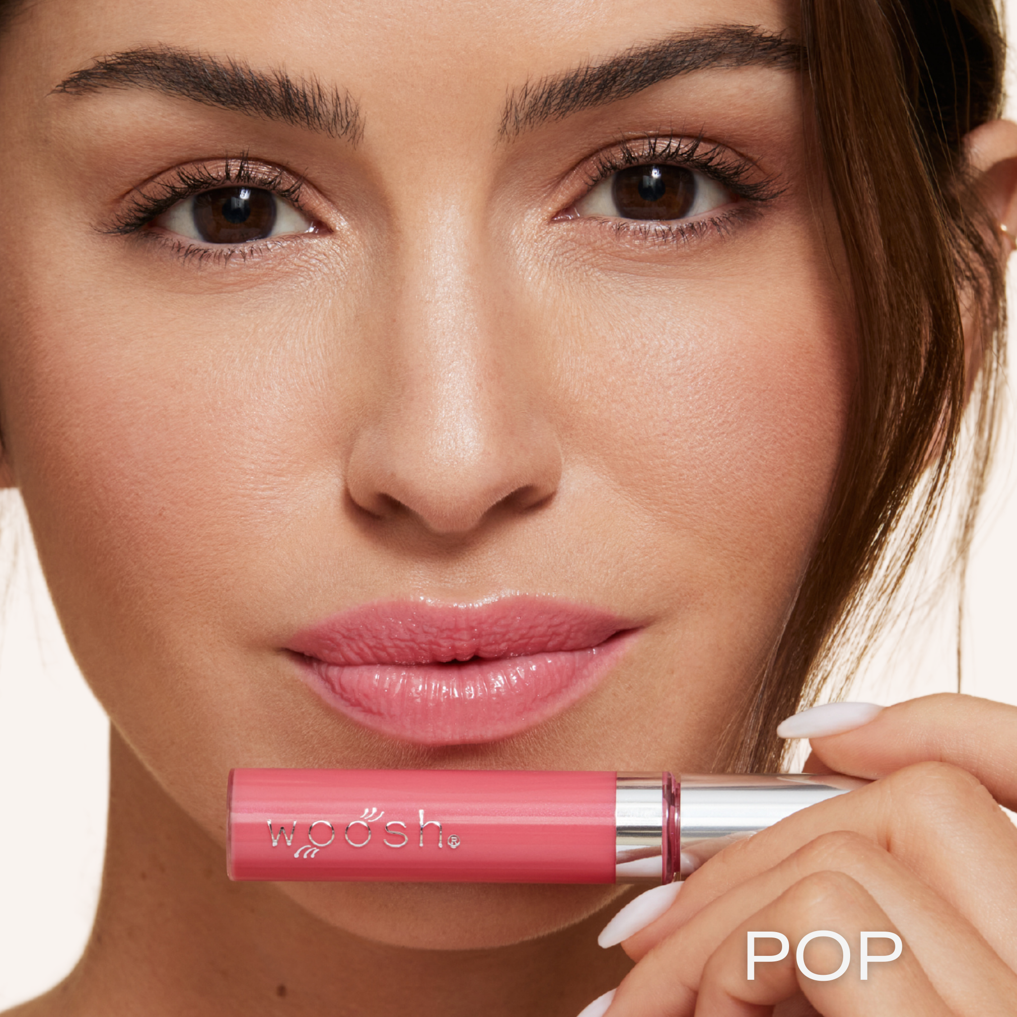Previously known as pink natural, pop is now infused with shea butter and hyaluronic acid. The perfect pink pop of color shade. Photo of model holding bottle close to lip.