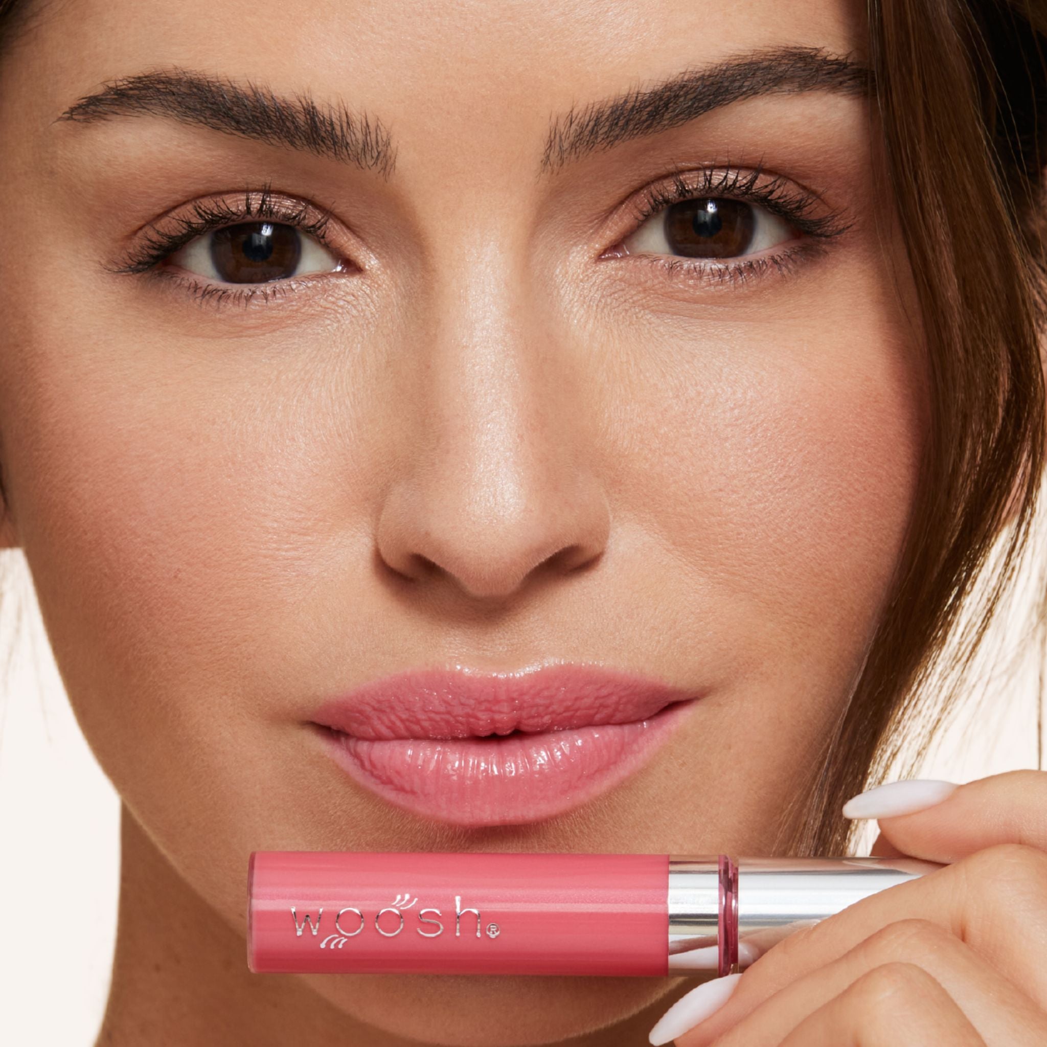 Previously known as pink natural, pop is now infused with shea butter and hyaluronic acid. The perfect pink pop of color shade. Photo of model holding bottle close to lip.