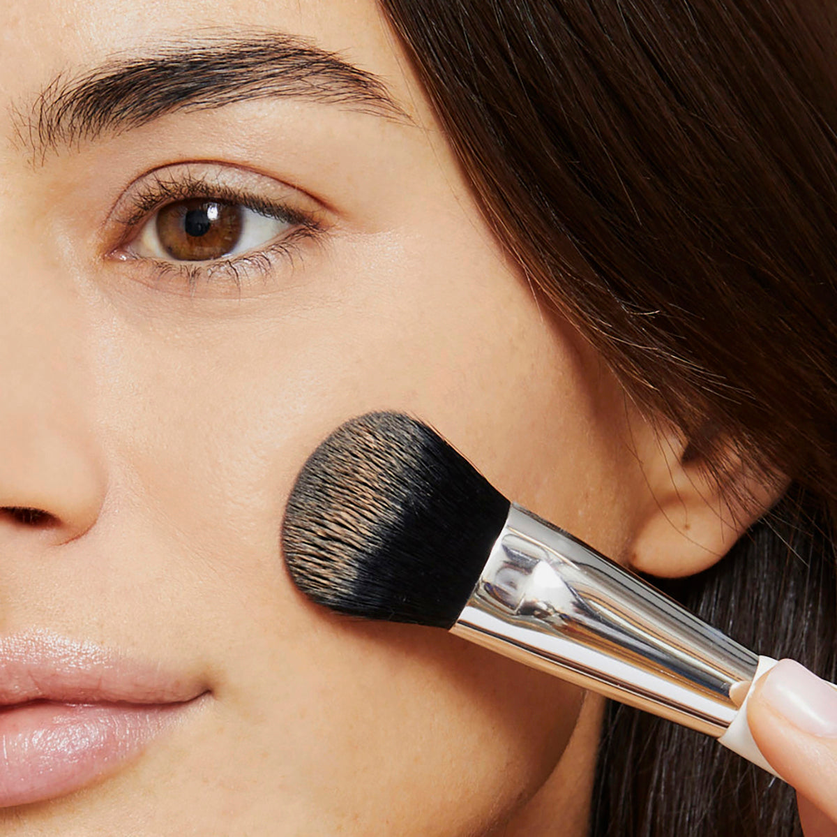 Application of creamy concealer or foundation to under eyes and on blemishes using the smaller end of the Woosh Complexion brush