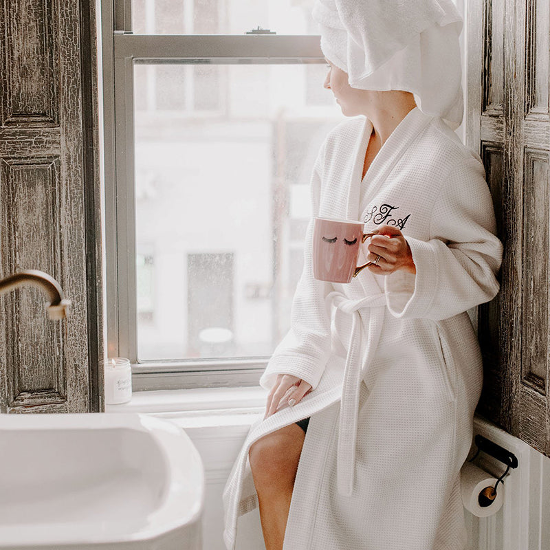 Model holding the wakeup to makeup pink coffee mug
