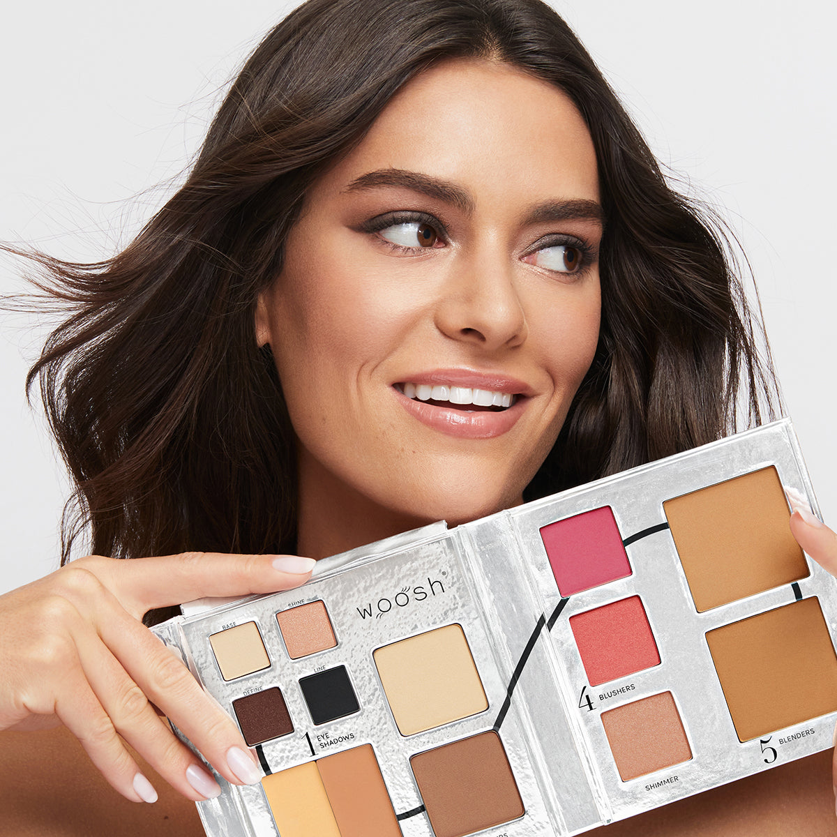 a photo of a slightly tan model wearing beautiful, natural-looking makeup holding the Fold Out Face palette in shade #2.5 medium tan