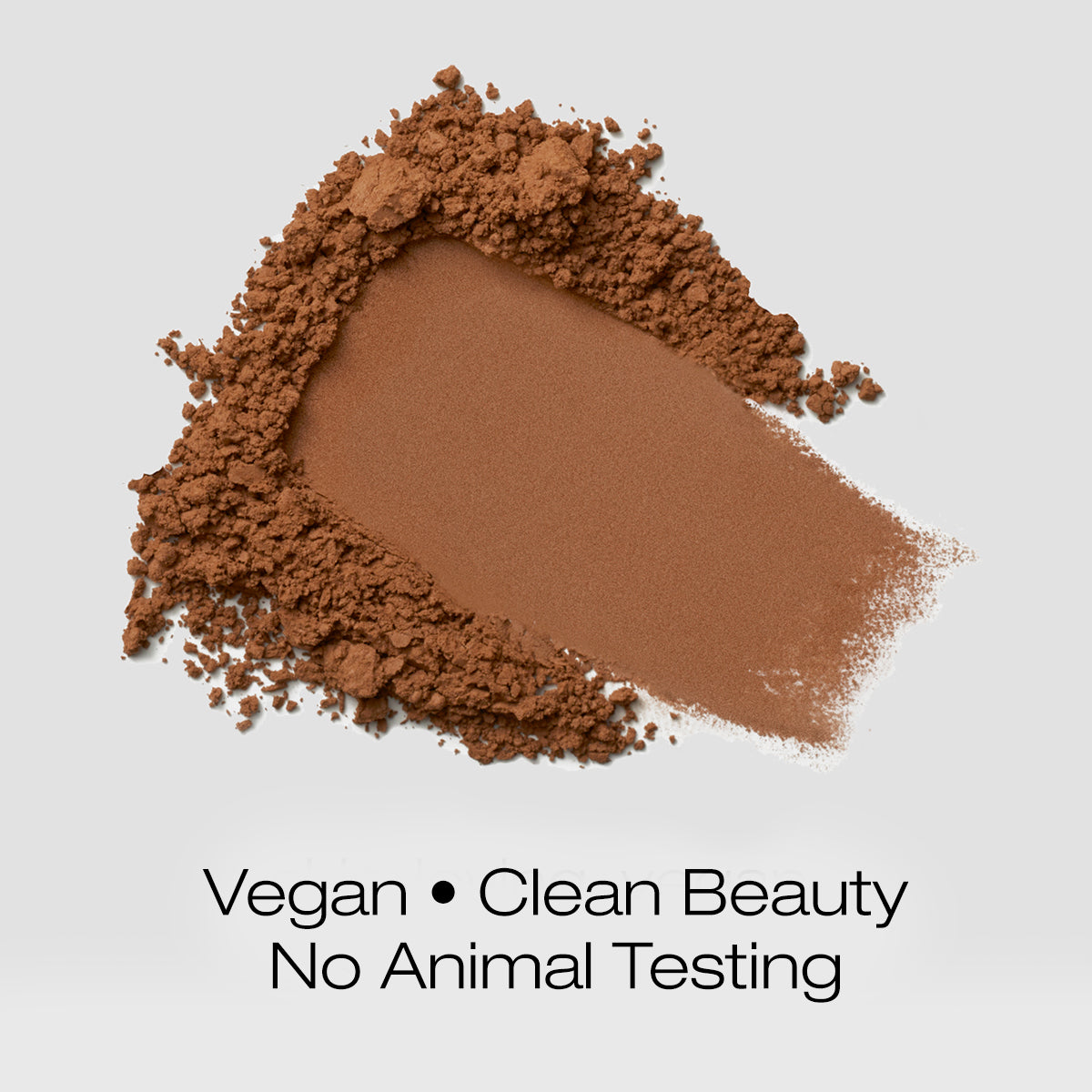 a swatch of warm brown colored foundation powder indicating that the formula is vegan, clean beauty and is not tested on animals