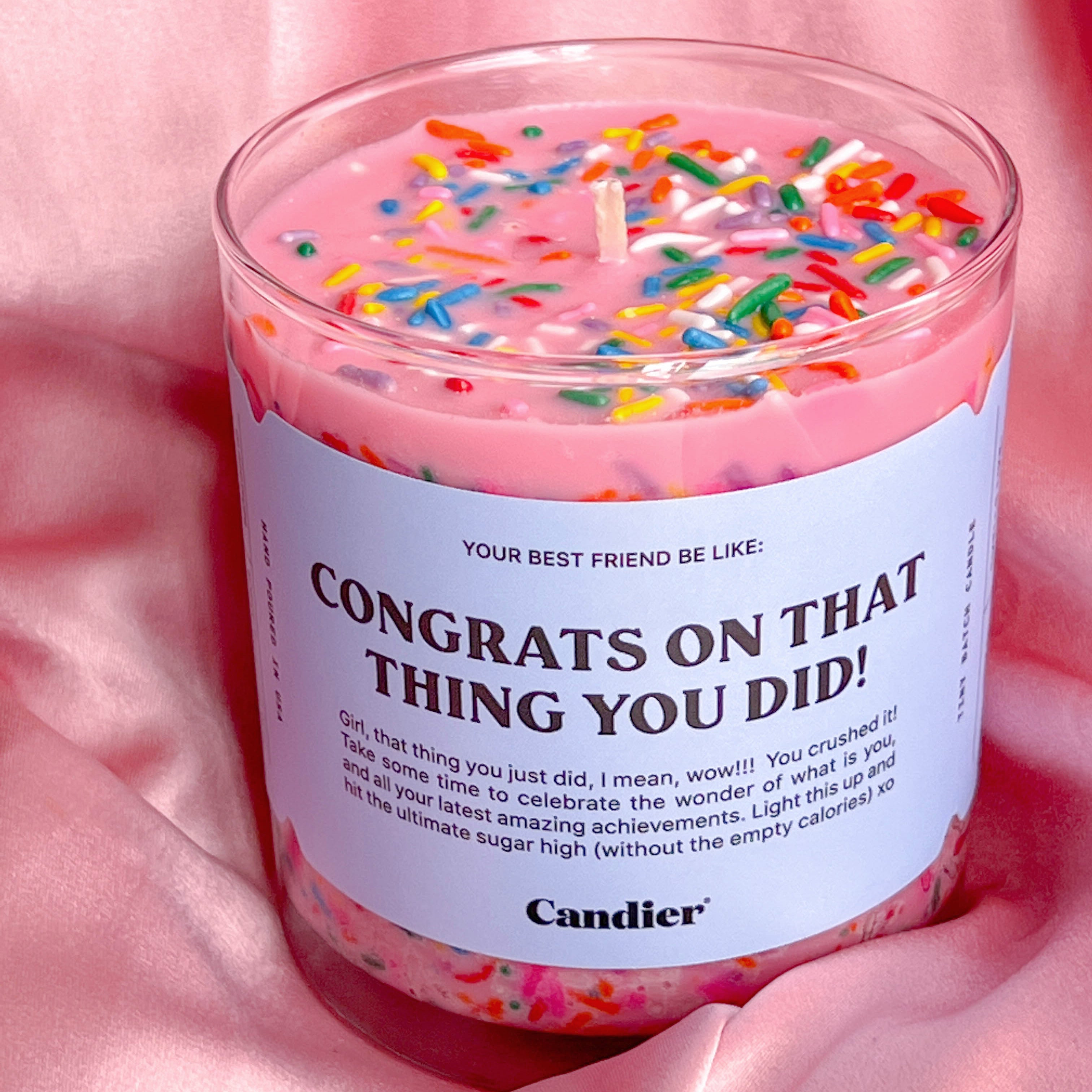 Top view of the "Congrats on that thing you did!" pink Candle by Candier with sprinkles displayed in silk