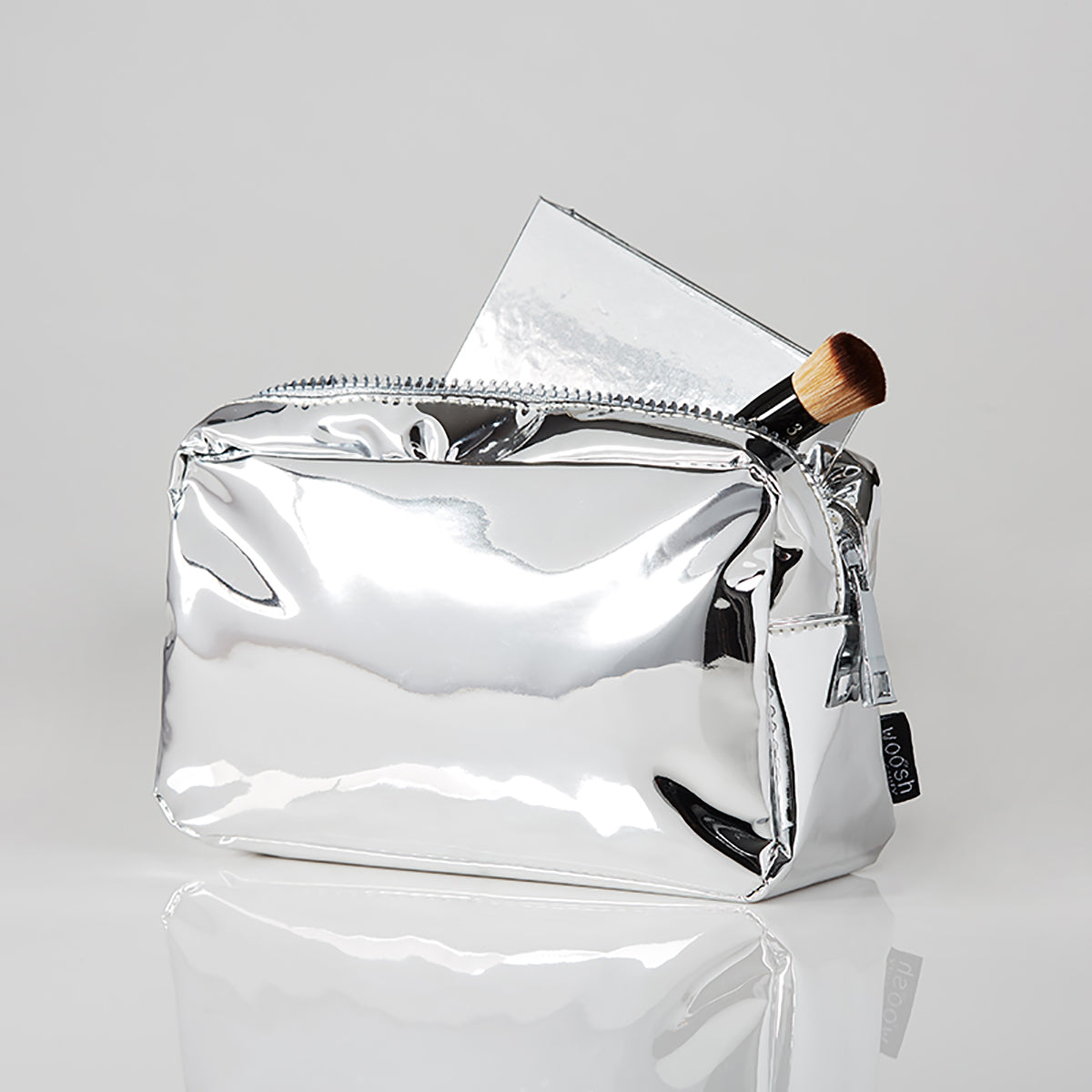 Demonstration of the silver essential medium makeup bag with assorted items