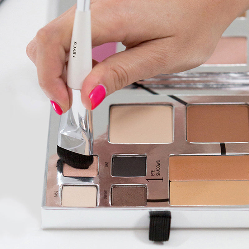 Fold Out Face palette opened. Model is using the eye brush from the essential brush set in shine eyeshadow color. 