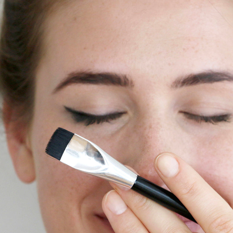woman showcases arc brush with angled eyeliner brush