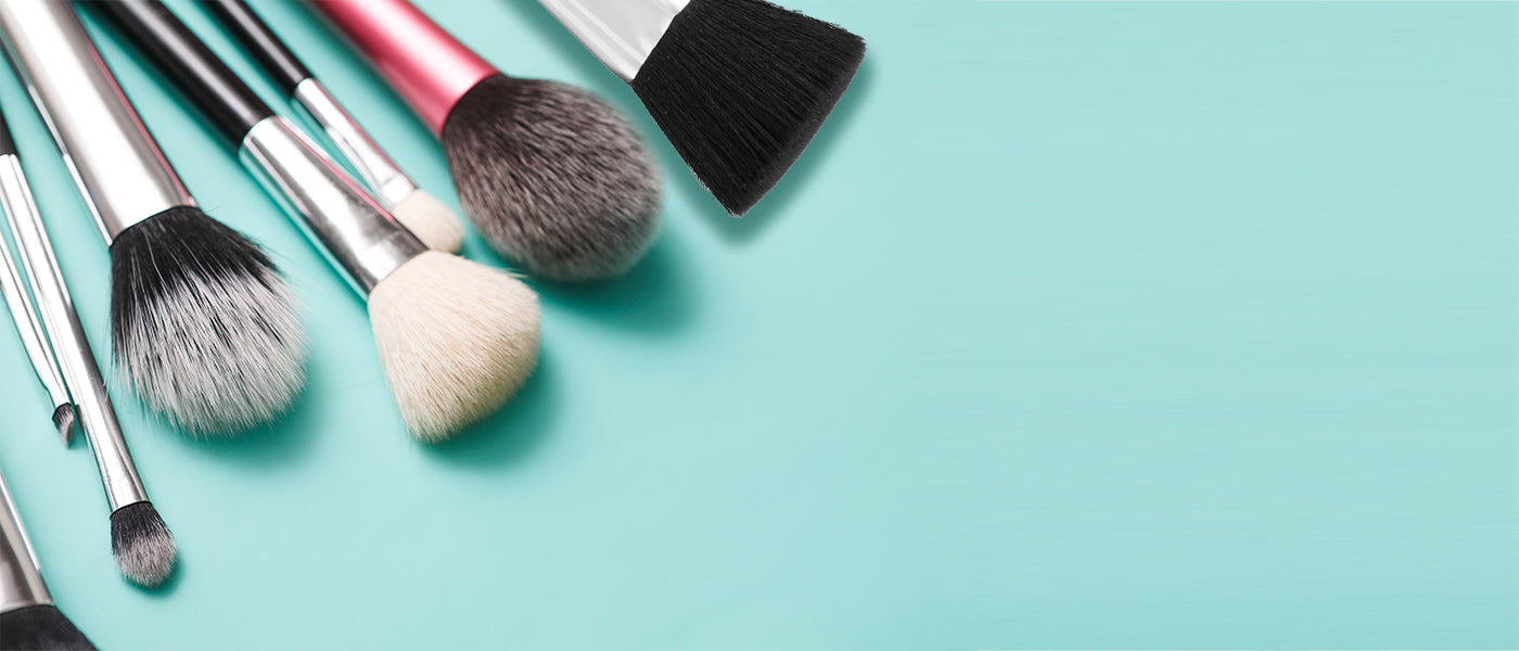 Makeup brushes in the corner in front of a blue background