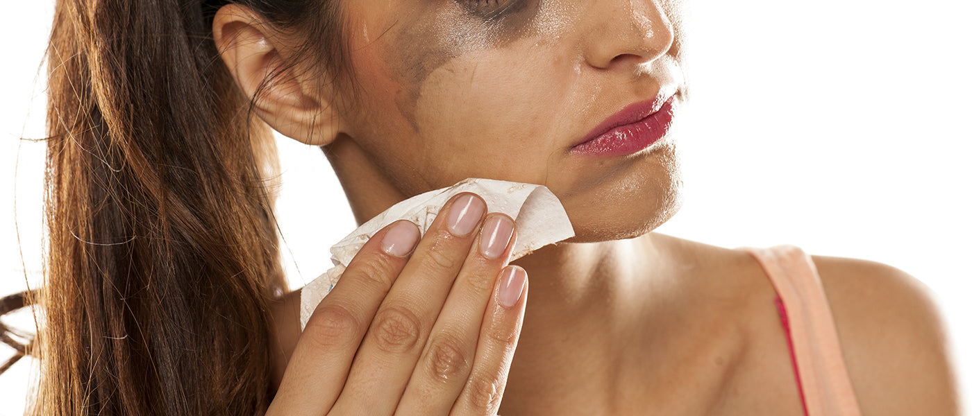 Model wiping mascara off of her face using a makeup wipe