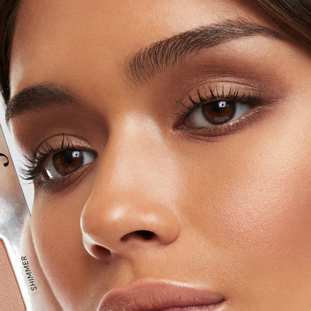 Close up of a brunette woman's brown eyes with beautiful brown and golden eyeshadows and mascara