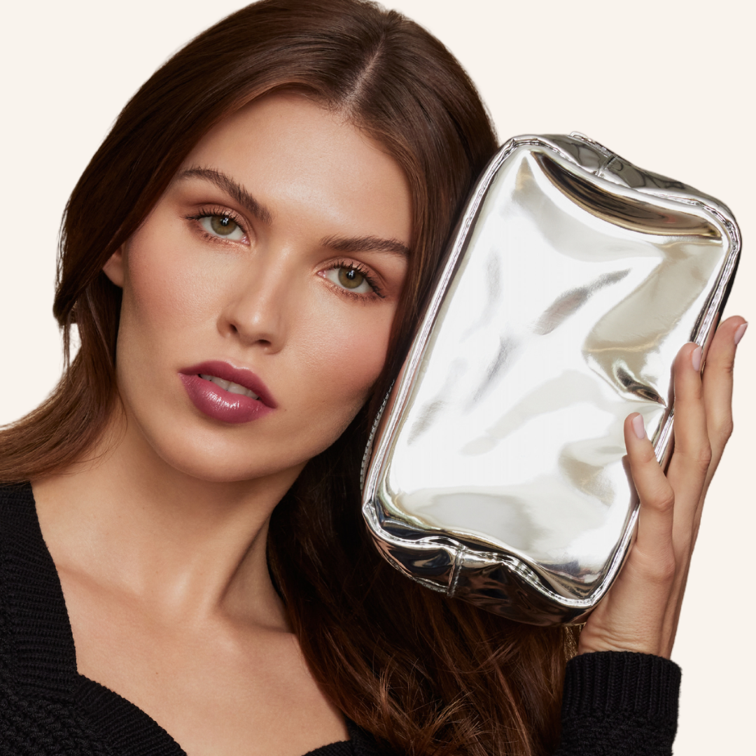 Model holding our platinum silver bag next to her face