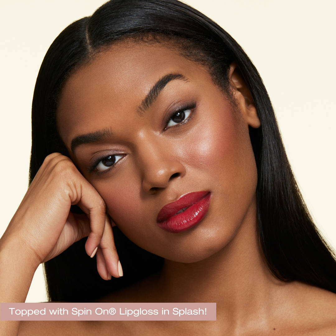 darker skin model with devoted on lip. topped off with splash spin on lip gloss