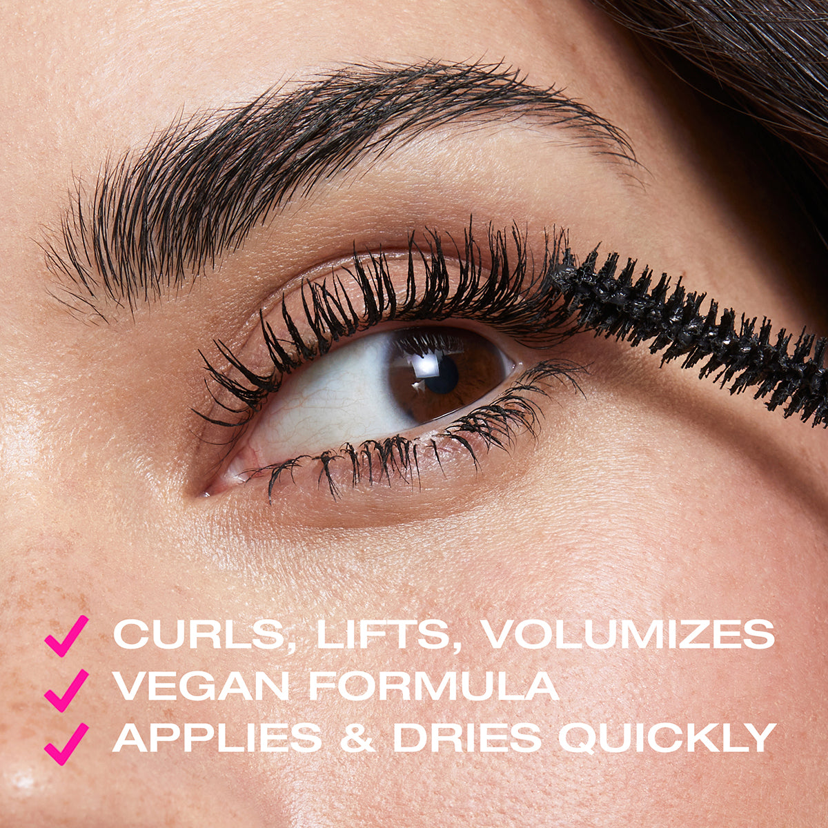 Woman applying mascara to eyelashes using mascara bristles with text saying it curls, lifts, volumizes, vegan formula, applies and dries quickly'