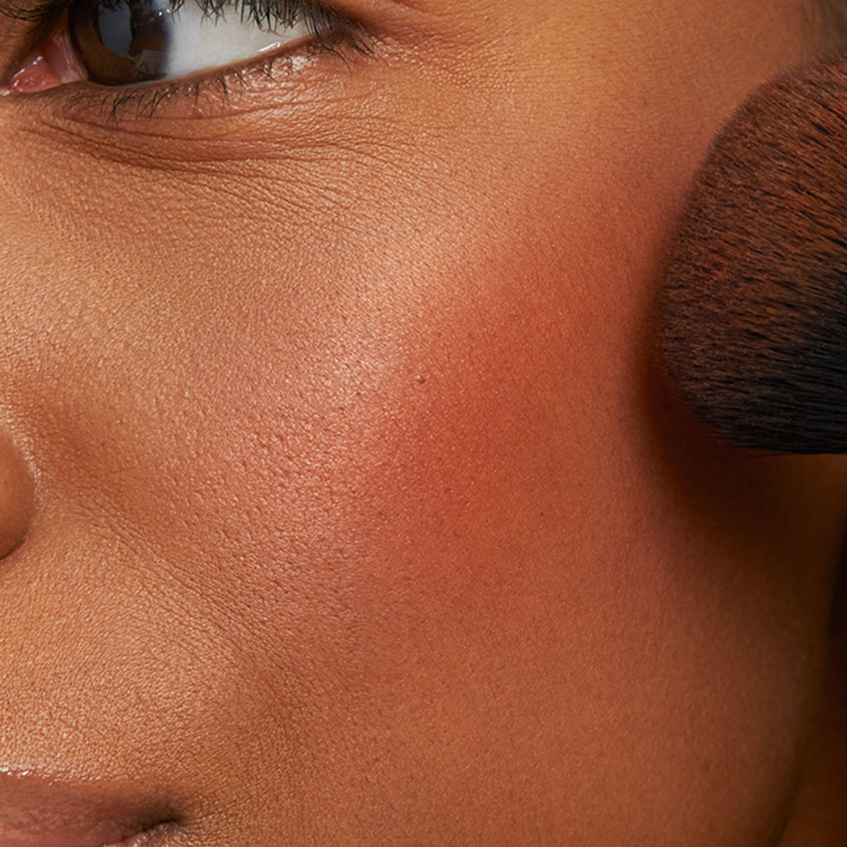 Model applying the Lychee blush to cheeks