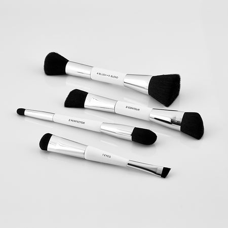 a photo of four high quality makeup brushes with white handles