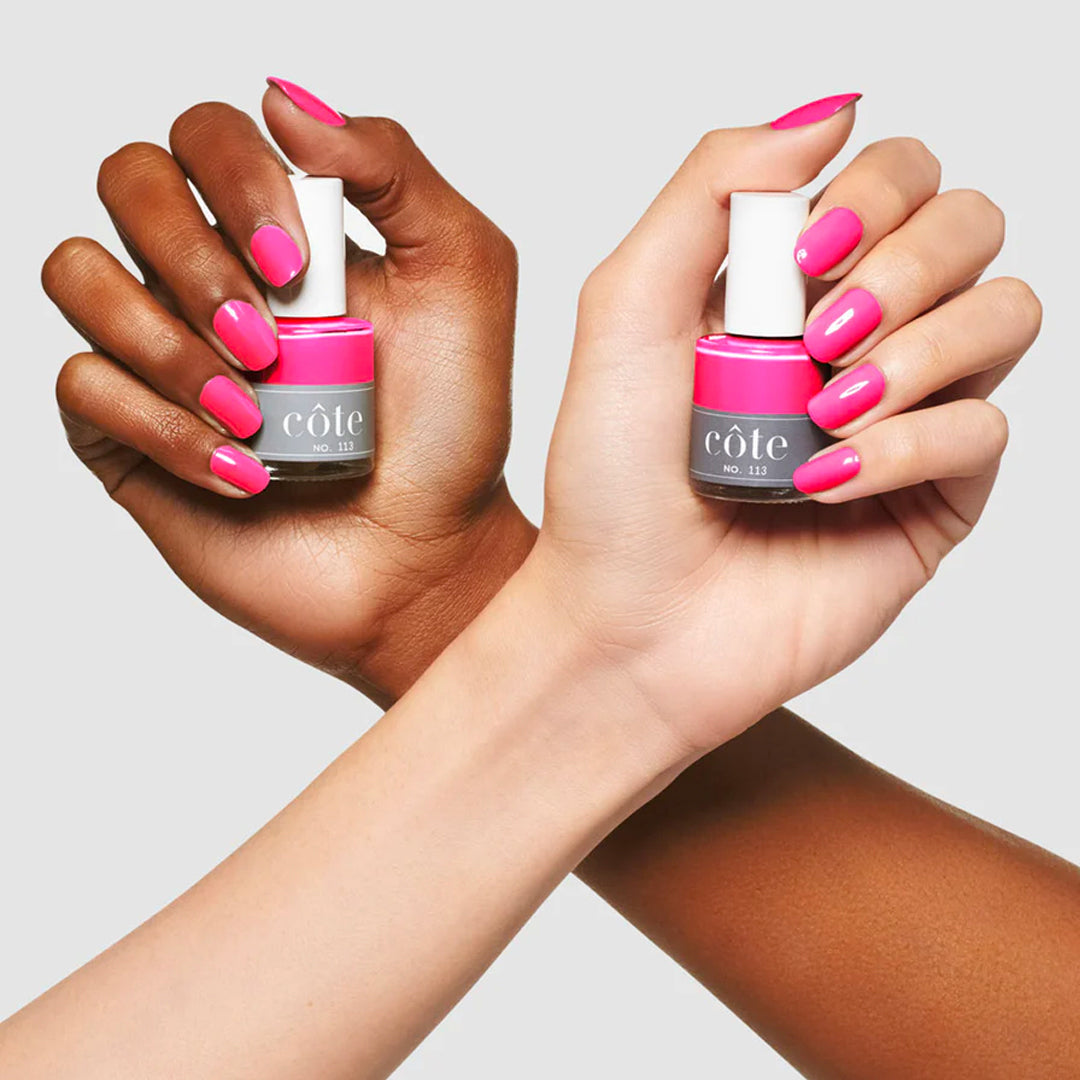 Models holding the Cote Neon Pink Nail Polish