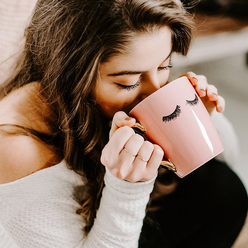 Model drinking from the wakeup to makeup coffee mug