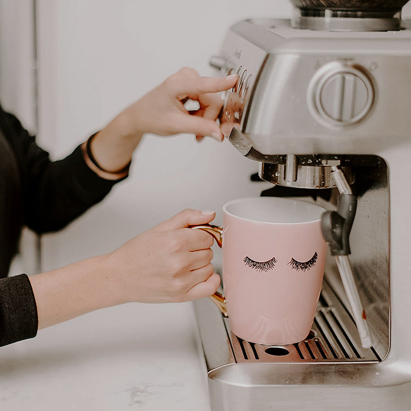 Model make a cup of coffee with a coffee machine using the Wakeup to Makeup pink coffee mug