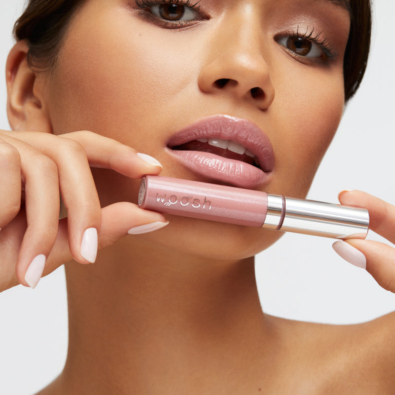 Model holding the beige frosted spin on lip gloss
