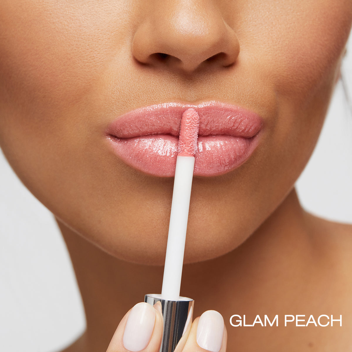Application of the vegan moisturizing shea butter gloss to lips in shade glam peach