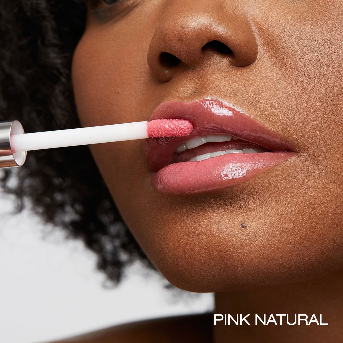 Pink natural spin on lip gloss applied to lips demonstration