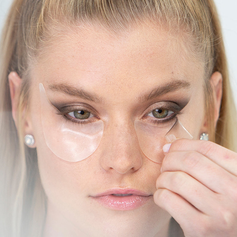 model gently peeling mascara sheild guard off under eye to show perfect eyeshadow look
