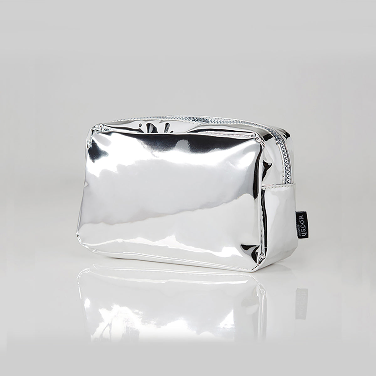 Angled view of the Woosh Beauty silver essential medium makeup bag