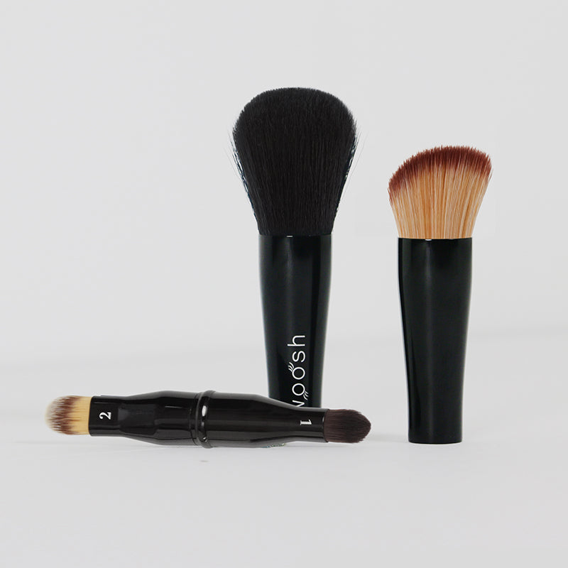 Three face brushes including concealer, contour, and powder/blush and one eye shadow brush pulled apart to see the options available in the nesting brush.